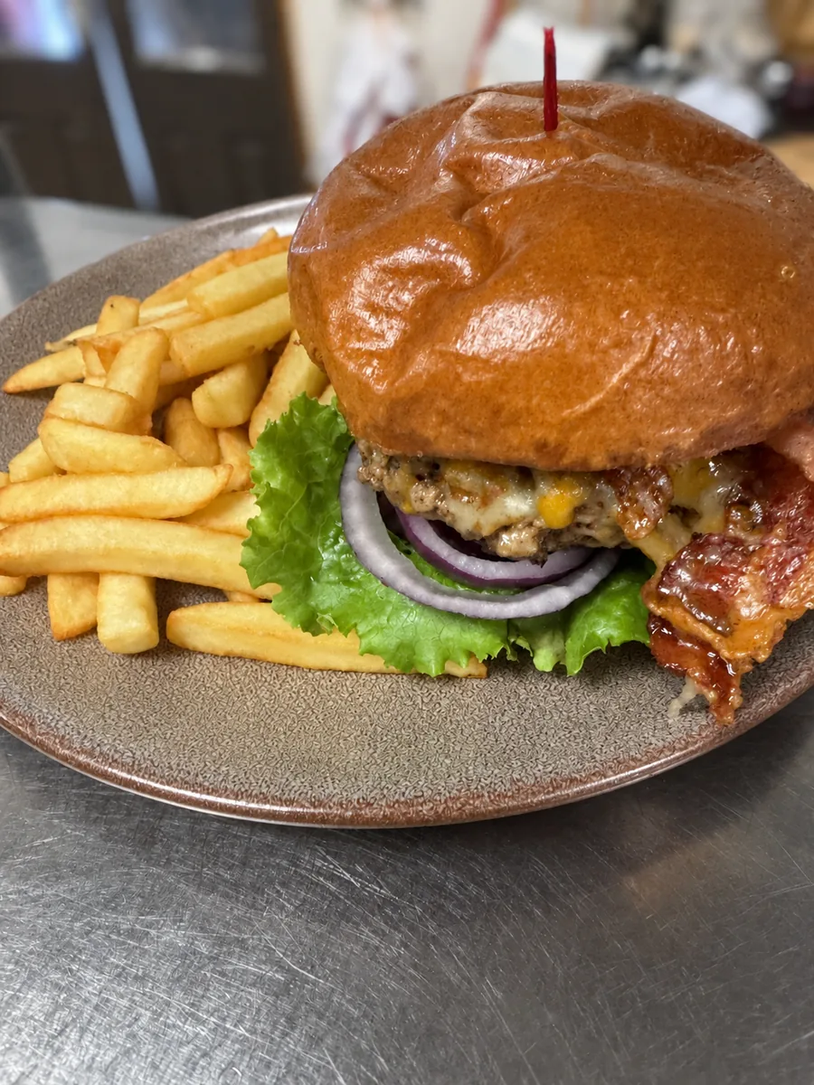 Bacon cheddar burger with a pile of fries