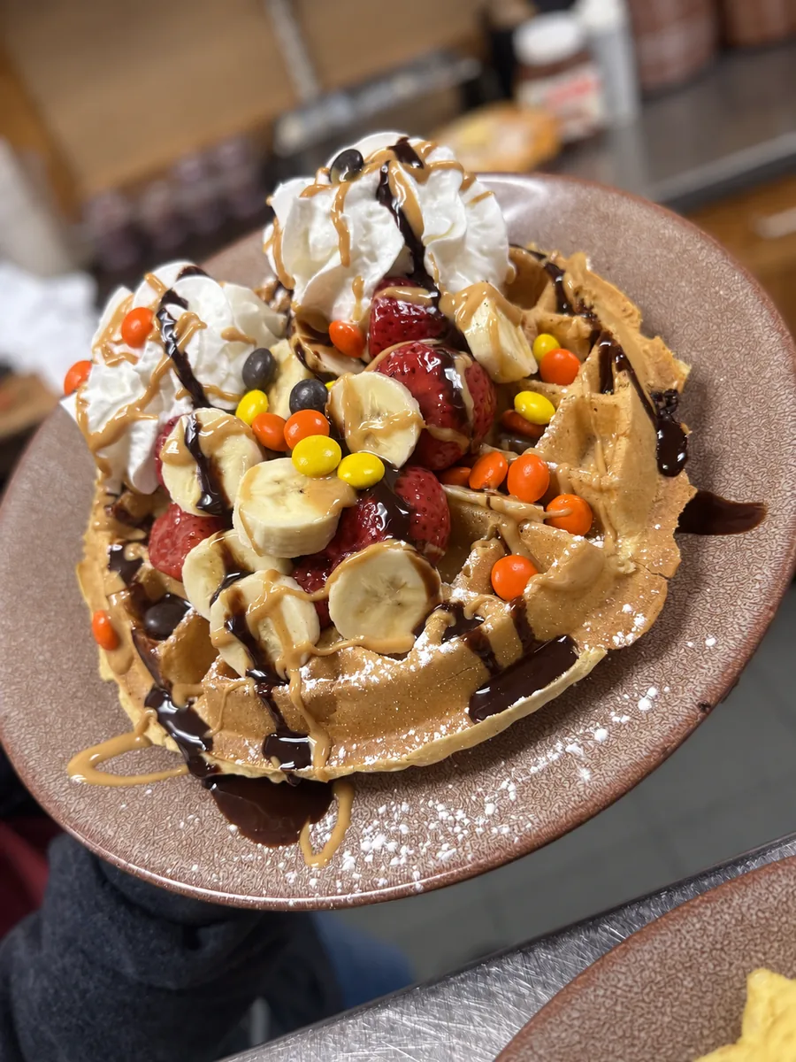 Loaded Reese’s waffle with whipped cream and peanut butter cups